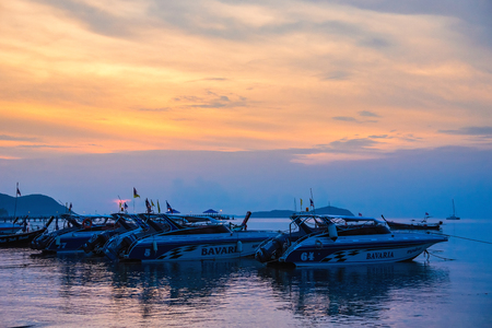 Phuket, Thailand - March, 31, 2019 : Sunrise above Tour boat on the beach. morning light shines up from the edge of the sea. A reflection on Tour boat parked on Rawai beach.Phuket, Thailandのeditorial素材