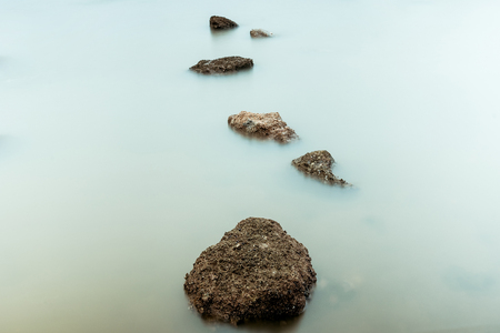 Long Exposure Photography of Waves on stone beach waters edge abstract sea background.Thailand.の写真素材