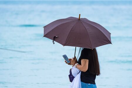Rayong, Thailand - May, 11, 2019 : Unidentified name Woman Walking holding an umbrella on the beach at Vongdeuan beach sunset in the Koh Samet island, Rayong, Thailandのeditorial素材