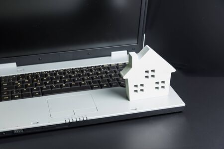 wooden white hose model on laptop notebook.Online shopping concept.Real estate concept, New house concept.Buying a house.の写真素材