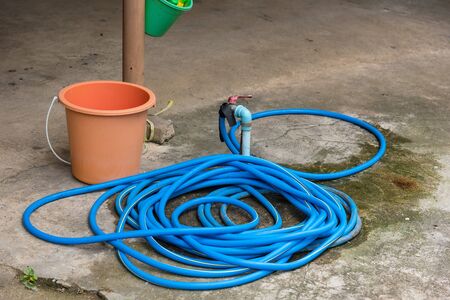 Rubber tube connected to old water tap on the floorの写真素材