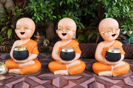 Novices carrying a bowl Statue of novice monks in temple Thailand Buddhistの写真素材