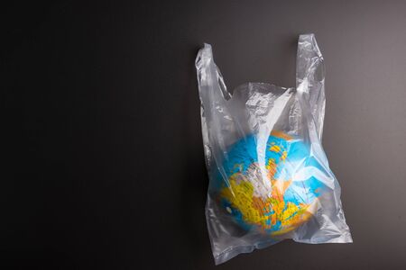 Plastic bag Earth world globe isolated on black background. Saving the planet Earth from plastic bags conceptの写真素材