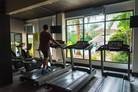 Chon Burii, Thailand - October, 05, 2019  : Unidentified name asian man in sportswear running on treadmill at gym in the tide hotel at Chon Burii, Thailand. Running fast.のeditorial素材