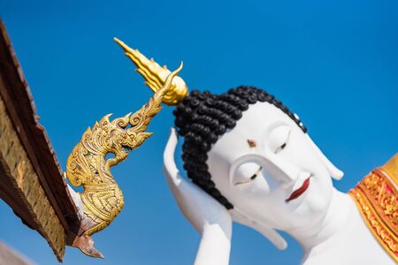 Buddha statue Reclining Buddha at Wat phra that doi kham with blue sky background.の写真素材