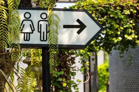 Metal toilet signs label on metal pole at outside buildingの写真素材