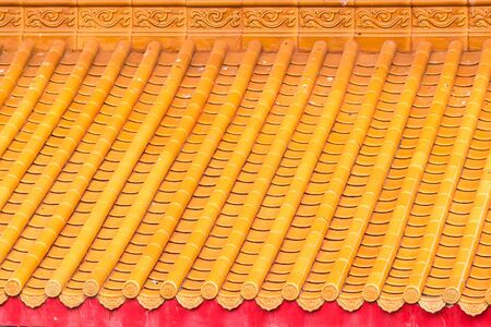 Yellow orange glazed terracotta  roof tiles of a Chinese temple.の写真素材