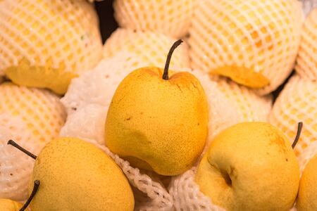 Close-up detail of multiple organic Asian pears at a local market. Fruits and nutrition concept.の写真素材