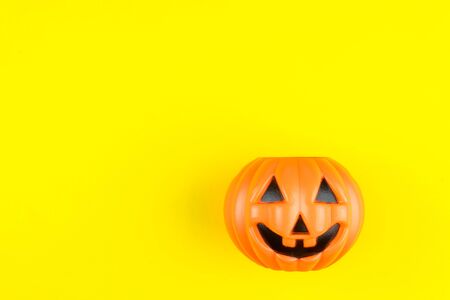 Jack O' Lantern Halloween pumpkin isolated on yellow backgroundの写真素材