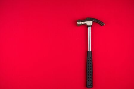 Shining Metal hammer on red background closeup.top view. Space for textの写真素材