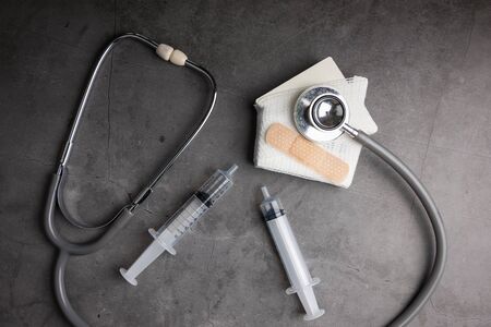 Wooden model white houses and first aid equipment on a cement gray background. Concept home repair, Home improvement, Renovate home.の写真素材