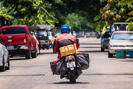 Bangkok, Thailand - May, 05, 2020 : Thailand Post, Postman is delivering packages to customers at Bangkok, Thailandのeditorial素材