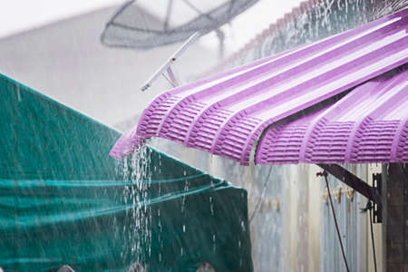 Heavy rain, raindrops run from the tiled roof. Weather forecast.Thailand.の写真素材