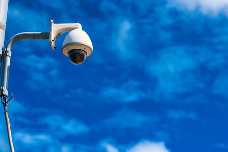 Security camera on a pole against blue sky background.の写真素材