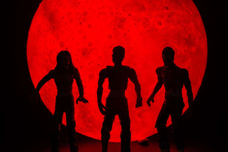 The silhouette of Halloween zombies decorations.There's a red full moon in the background. Halloween...
