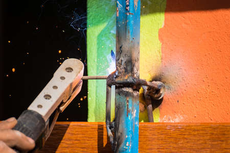 The welder is welding the various parts of the house construction.