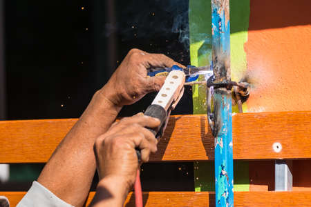 The welder is welding the various parts of the house construction.
