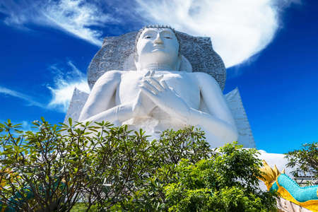 White big Buddha statue nearby the mountain at Wat Tham Phra That Khao Prang, Lopburi, Thailandの写真素材