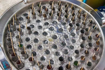 Traditional ice cream making in stainless tube by rotation in tank with ice and salt
