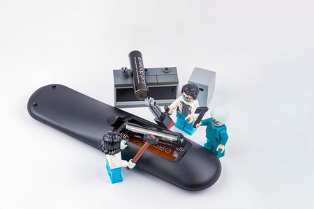 Bangkok, Thailand - November, 24, 2020 : Lego doctors are helping to change the battery the TV remote control.のeditorial素材