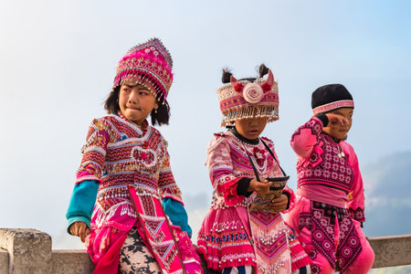 Phetchabun, Thailand - November, 29, 2020 : Hmong children in traditional clothes wait for pictures with tourists on mountain Phu Tub Berk, famous travel location beautiful sea fog at Phetchabun, Thailandのeditorial素材