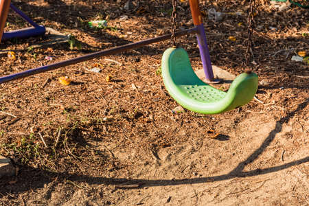 Empty swing with chains on the playgroundの写真素材