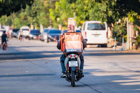 Bangkok, Thailand- March 01, 2021 : Delivery service man ride a Motercycle Online delivery to villages in Bangkok, Thailandのeditorial素材