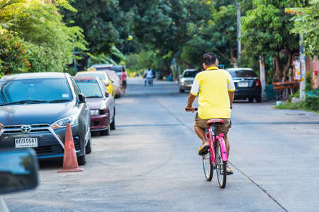 Bangkok, Thailand- March 01, 2021 : Unidentified old man rode a bicycle in the evening in the village. at Bangkok, Thailand.のeditorial素材