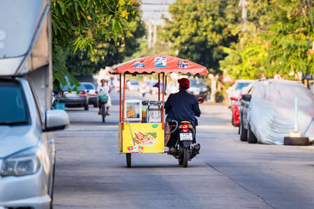 Bangkok, Thailand- March 01, 2021 : Unidentified man on a motorbike selling food in the village at Bangkok, Thailand.のeditorial素材