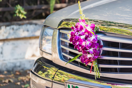 Bangkok, Thailand- March 01, 2021 : The bouquet of flowers is used to worship the sacred objects of the car in front of the car.の写真素材