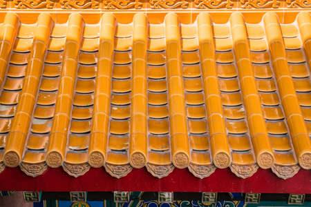 Yellow orange glazed terracotta roof tiles of a Chinese temple.の写真素材