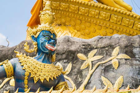 Nakhon Nayok, Thailand - March, 28, 2021 : Golden statue of angel and demons doing tug of war with three-headed serpent, depicting good and evil contest at Maniwong Temple at Nakhon Nayok, Thailand.のeditorial素材