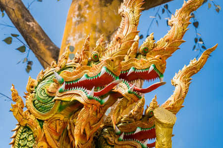 Nakhon Nayok, Thailand - March, 28, 2021 : Golden statue of serpent at Maniwong Temple at Nakhon Nayok, Thailand.のeditorial素材