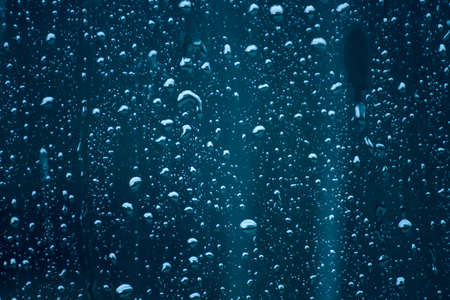 The day was heavy rain, the weather was overcast.Rain water falls on the windshield of car.の写真素材