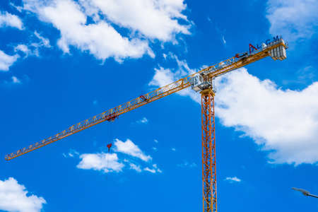 Bangkok, Thailand - May, 22, 2021 :Building crane and building under construction against cloudy sky...