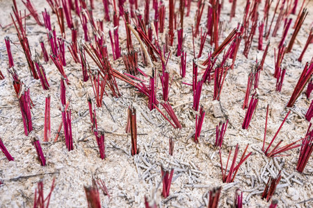 Incense sticks burning for prayer being put into the pot in buddhist temple outdoors.の写真素材