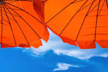 Red umbrella on the beach and blue sky symbolizing vacationing in summer.Thailand.の写真素材
