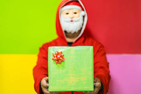 Bangkok, Thailand - December, 18, 2021 : Unidentified name man wearing cosplay dress up as santa claus standing holding gifts box.Concept christmas gift new year gift.のeditorial素材