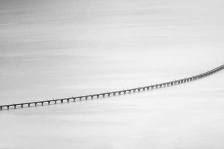 Black and white photo of Floating railway bridge popular travel destination in the middle of Pa Sak...