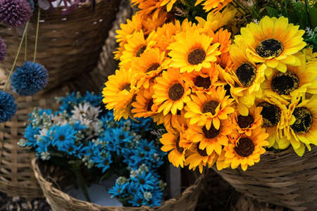 artificial flower bouquet of yellow, orange and burgundy marigold flowers.の写真素材