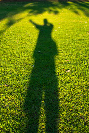 Shadow of man on lawn green background