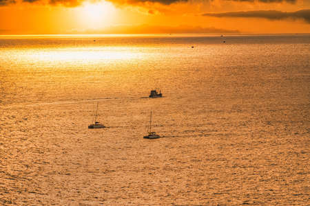 Silhouette scene of motor boat on Andaman tropical sea at sunset in phuket, thailand.の写真素材