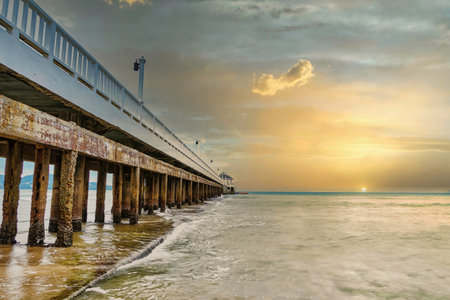 Side view of pier at the beach at sunset time.Thailand.