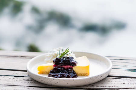 Delicious Cheesecake placing on wooden table in the background beautiful landscape.の写真素材
