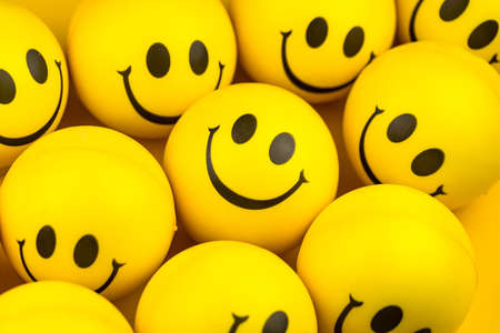 Happy faces ball on yellow background, smiling background.の写真素材