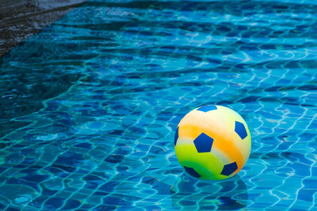 Inflatable colorful ball floating in a swimming pool.