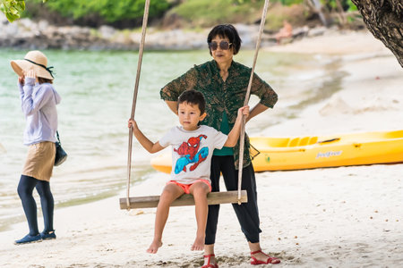 Rayong, Thailand - October, 15, 2022 : Asian grandmother have fun with her little boy to play together with swing at the Koh Samet island, Rayong, Thailandのeditorial素材