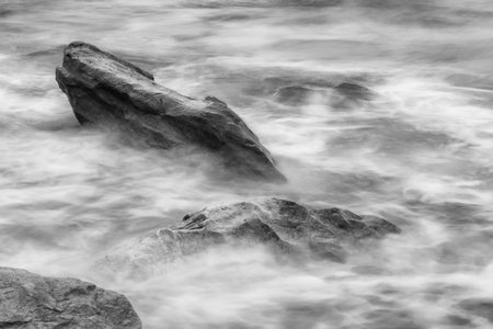 Black and white photos of Majestic Evening Seascape: Dramatic Waves Collide with Island Rocks in Eastern Thailand at Sunsetの写真素材