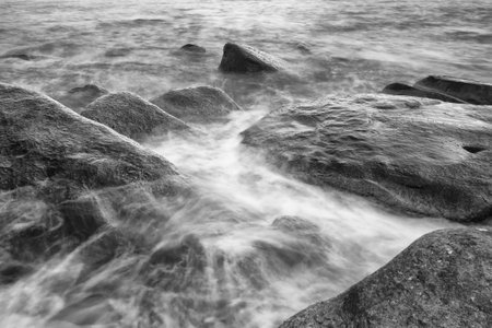 Black and white photos of Majestic Evening Seascape: Dramatic Waves Collide with Island Rocks in Eastern Thailand at Sunsetの写真素材