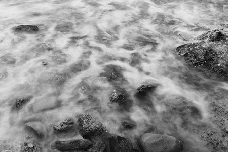 Black and white photos of Majestic Evening Seascape: Dramatic Waves Collide with Island Rocks in Eastern Thailand at Sunsetの写真素材